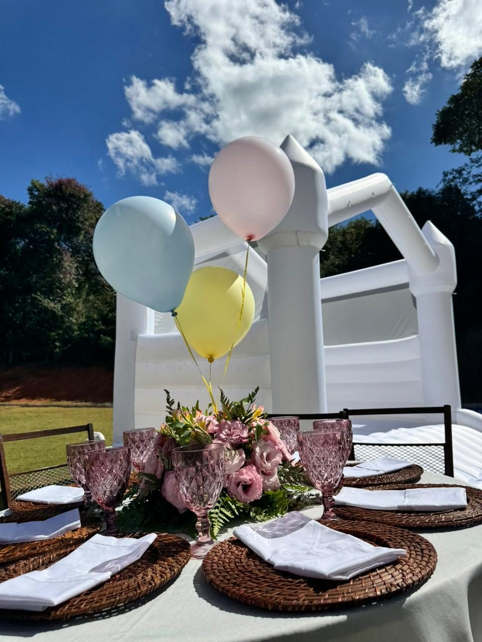 Bounce Castle branco da Pura Farra com mesa posta elegante e balões pastel