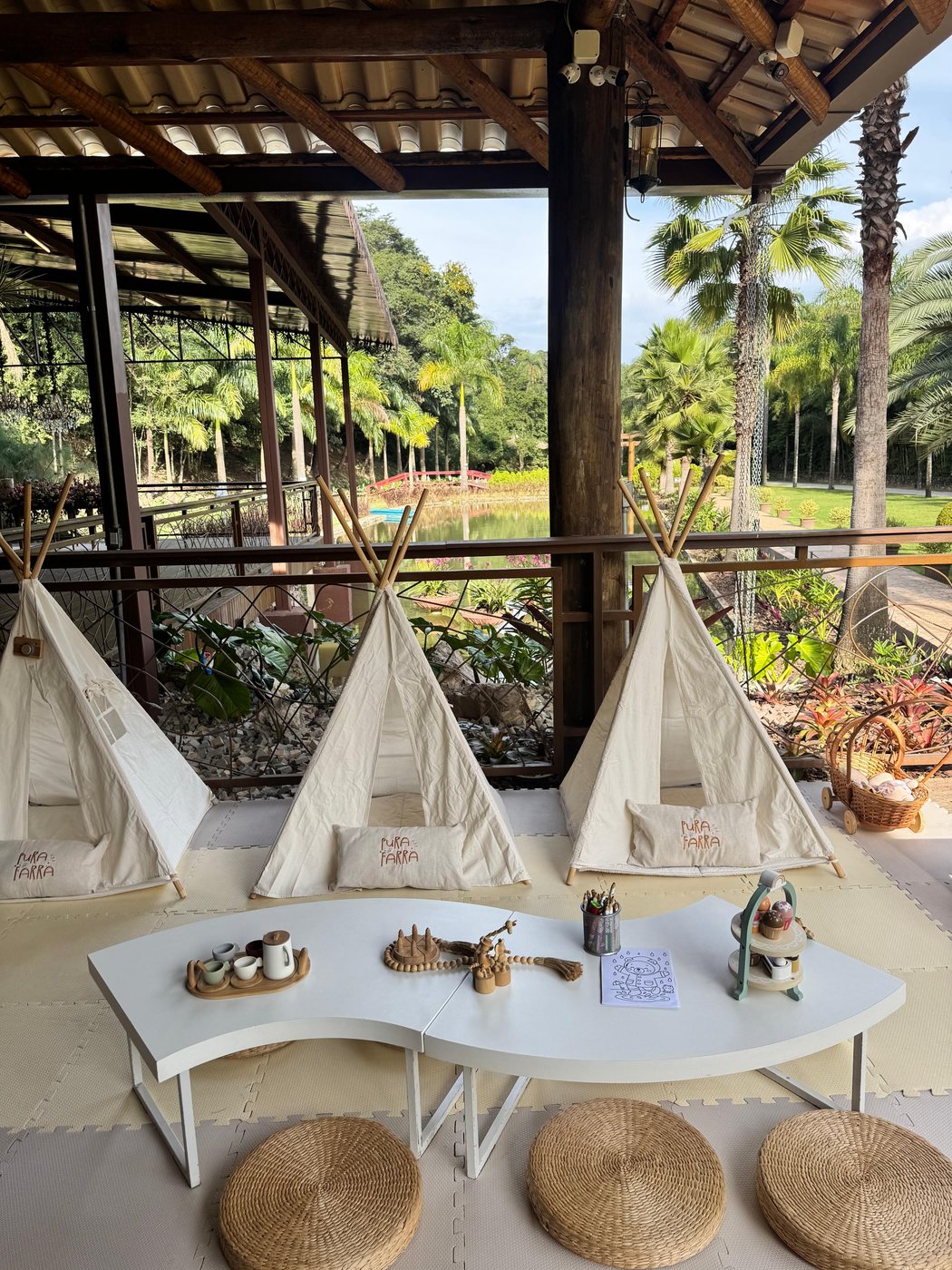 Cabaninhas teepee brancas montadas com mesa de atividades em pousada