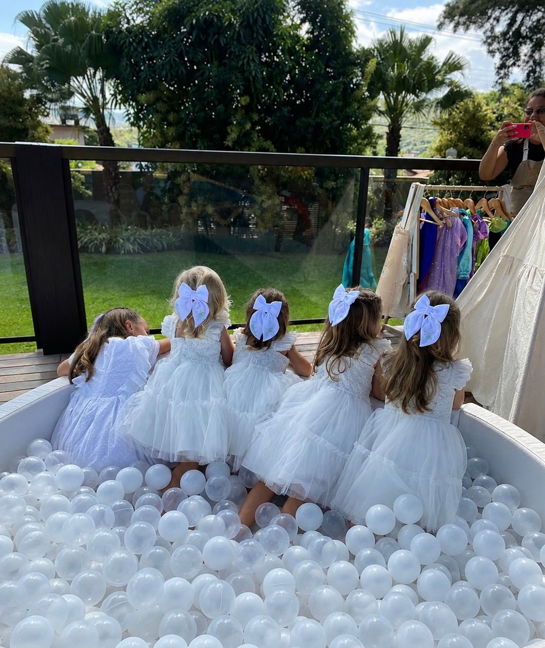 Daminhas de vestido branco brincando na piscina de bolinhas em casamento