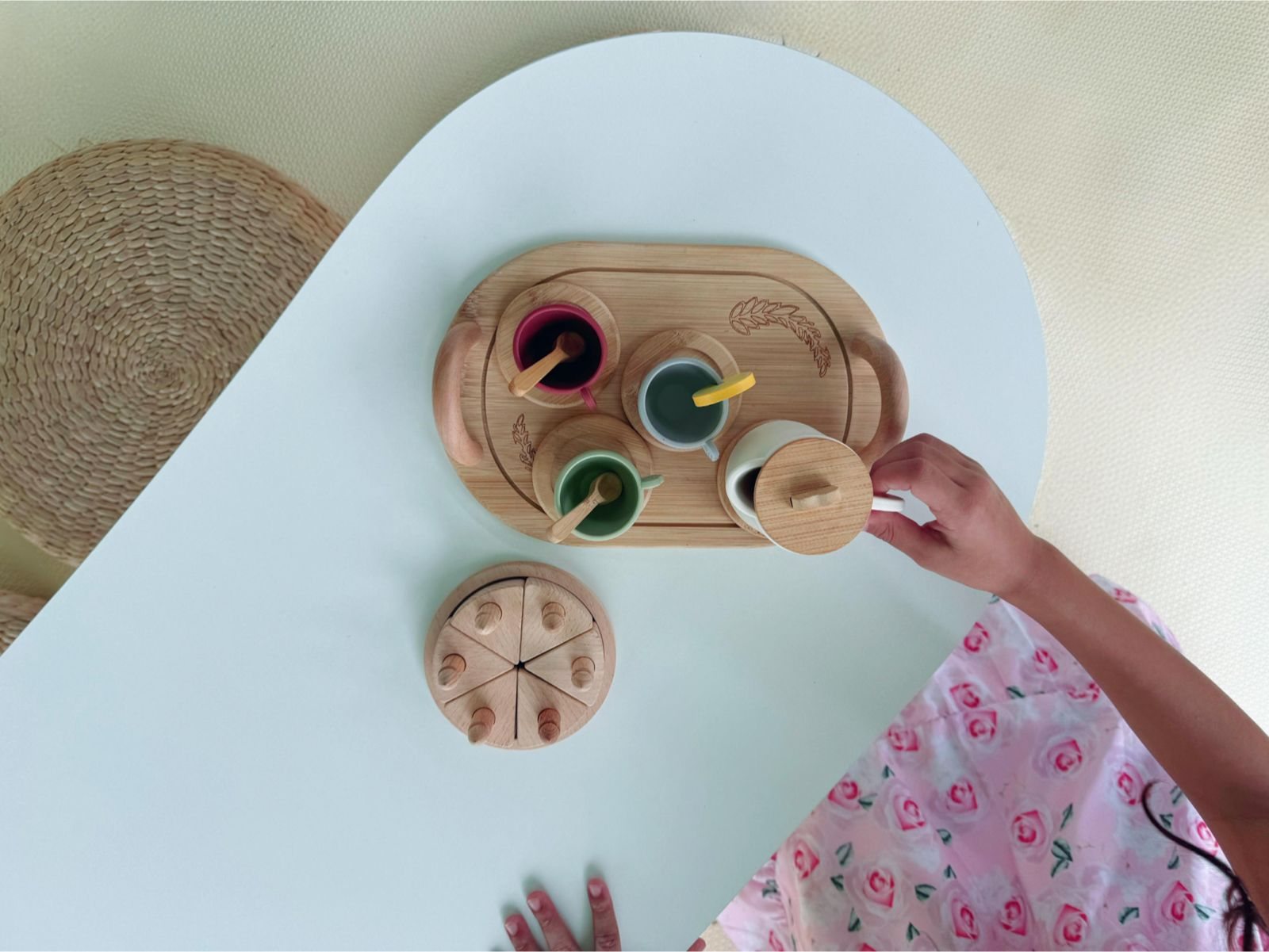 Mesa branca do Lounge Montessori da Pura Farra com jogo de chá de madeira e criança brincando