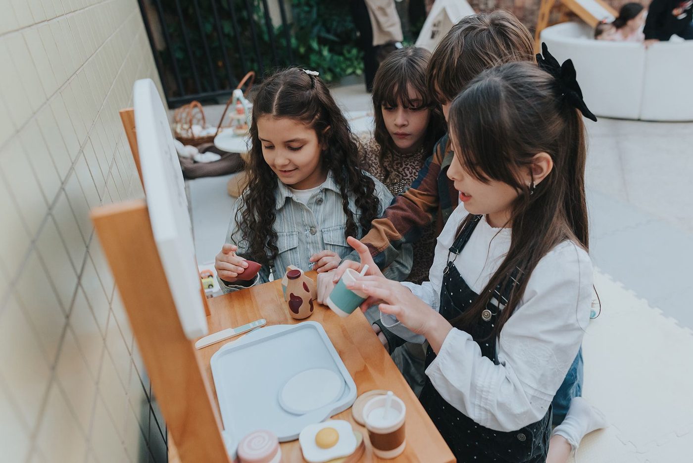 Crianças brincando na mini cozinha do lounge montessori
