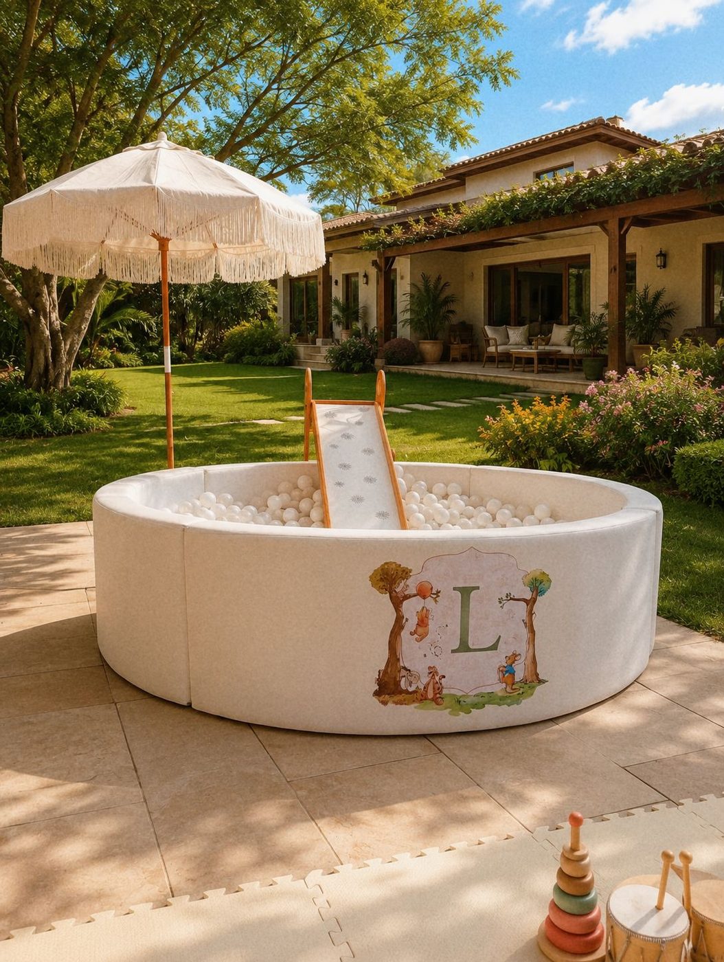 Piscina de bolinhas off-white com ombrelone de franjas montada no jardim